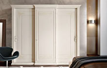 Wardrobe with 3 sliding doors and straight central hinged door, antique white glazed finish and ochre decorations
